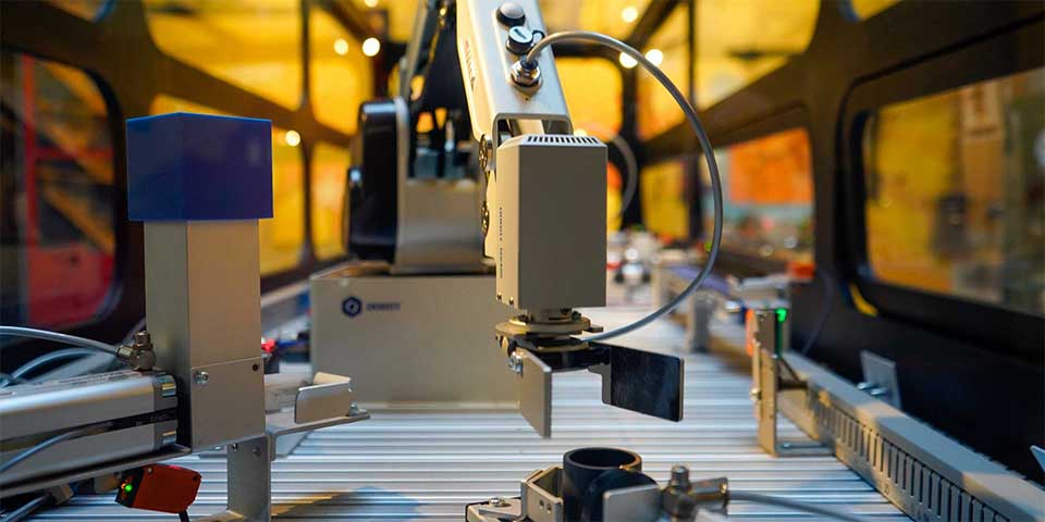 En robotarm bygger i en stängd miljö.