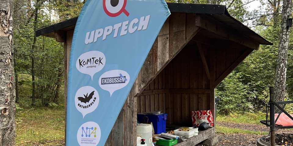 Upptech flagga, i bakgrunden ett skjul med kassar och mat.
